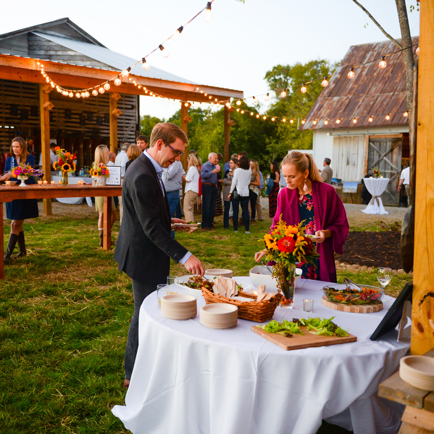Shalom Farms | People getting snacks from table at farm event
