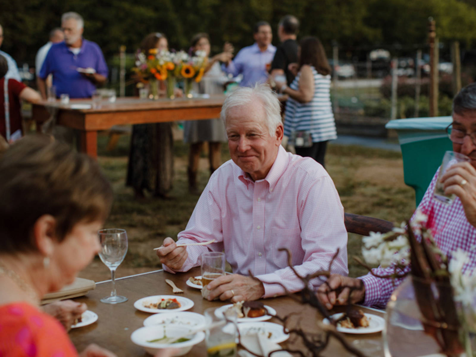 Shalom Farms | Group gathered at table eating at event