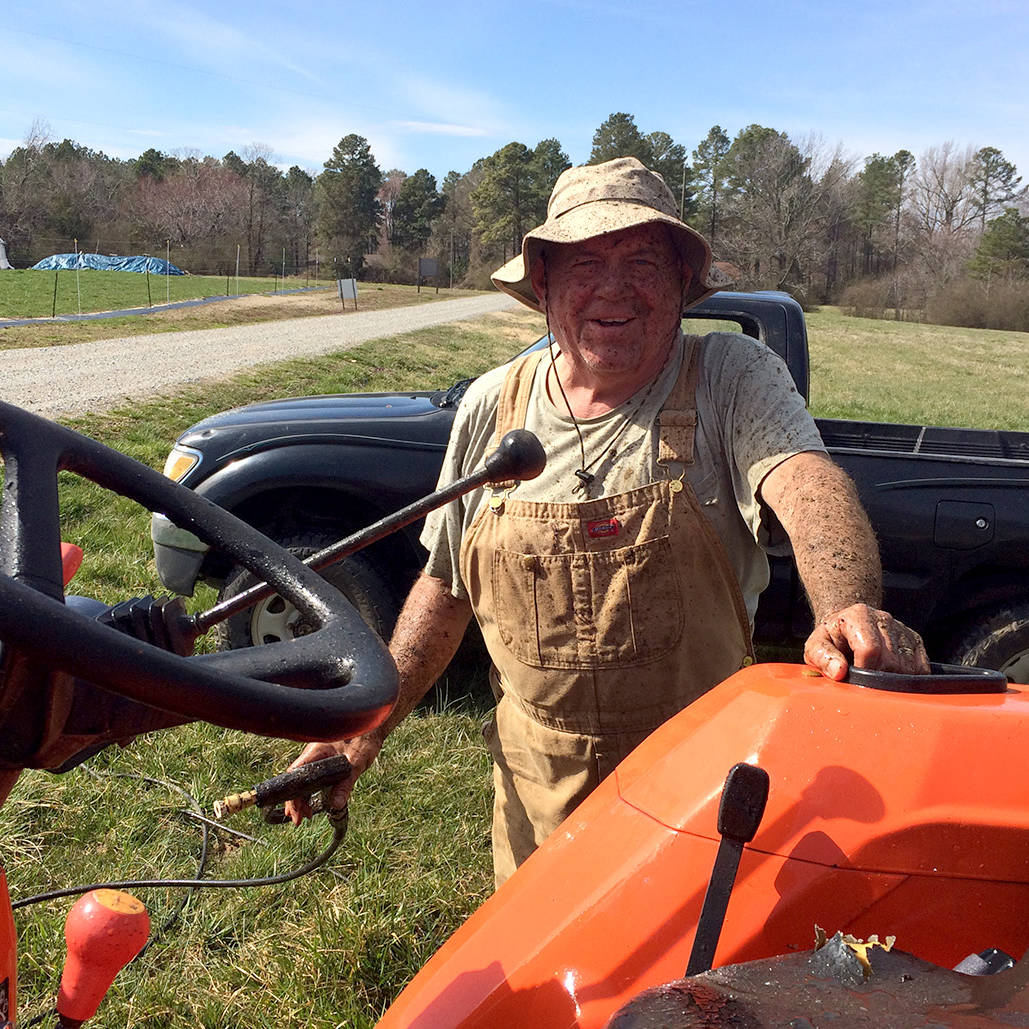 Shalom Farms Lead Volunteer standing near tractor